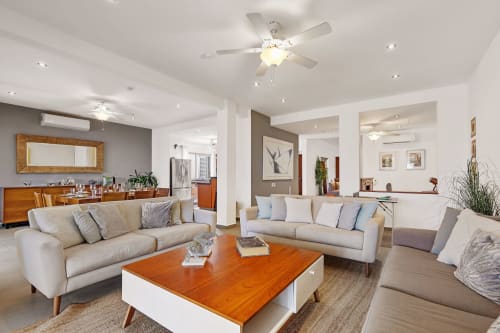 Spacious Villa Seven living room in Isla Mujeres with beige sofas, wood coffee table, and sea view access