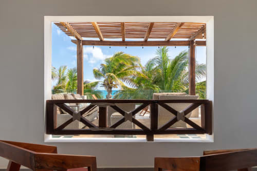 Isla Mujeres villa balcony with wooden pergola, sea view, palm trees, and lounge seating overlooking turquoise water