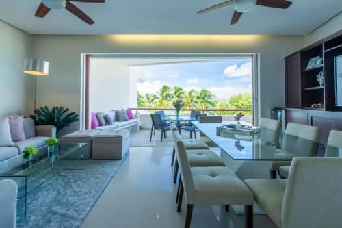 Modern sea view living room in Isla Mujeres condo with ocean balcony, contemporary furniture, and tropical landscape