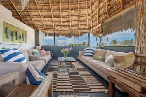 Beachfront villa lounge at Aruma Boutique Isla Mujeres with ocean views, thatch roof, and coastal decor