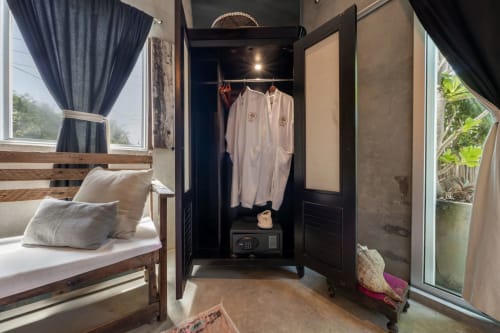Modern villa wardrobe with white robes, safe, and black built-in storage in Isla Mujeres boutique room