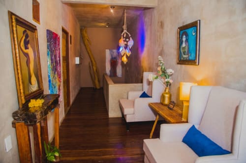 Aruma Boutique villa lounge in Isla Mujeres with cream seating, wood accents, framed artwork, and ambient lighting