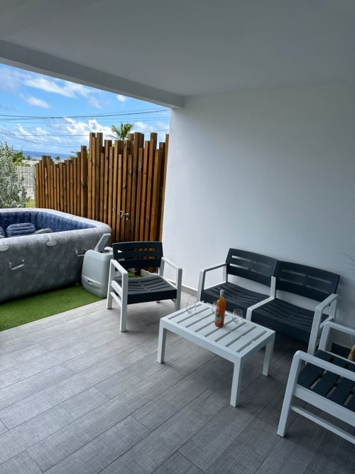Terrasse extérieure Maly Blue avec bain à remous, espace détente et clôture en bois à Le Moule