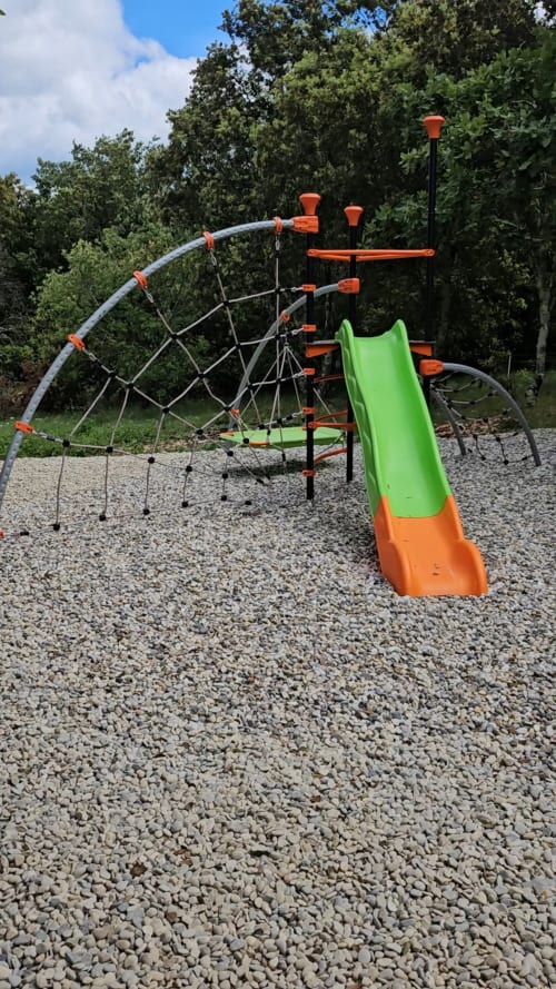 Colorful playground with green slide and orange trim at Domaine en Terre Happy garden, Labastide-de-Virac