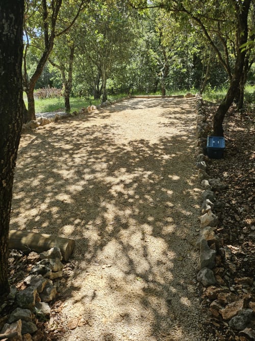 Tree-lined gravel path at Domaine en Terre Happy cottage in Labastide-de-Virac, France with garden views and natural shade