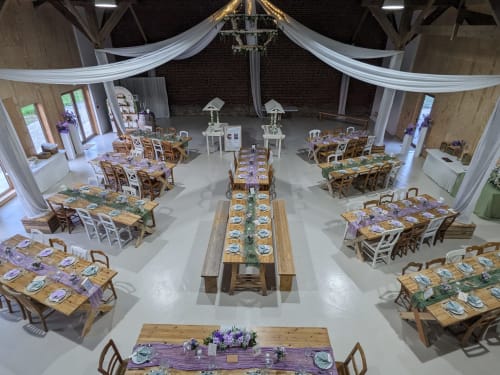 Réception de mariage champêtre à Domaine De La Souche, Rexpoëde avec tables en bois, accents violets et plafond drapé