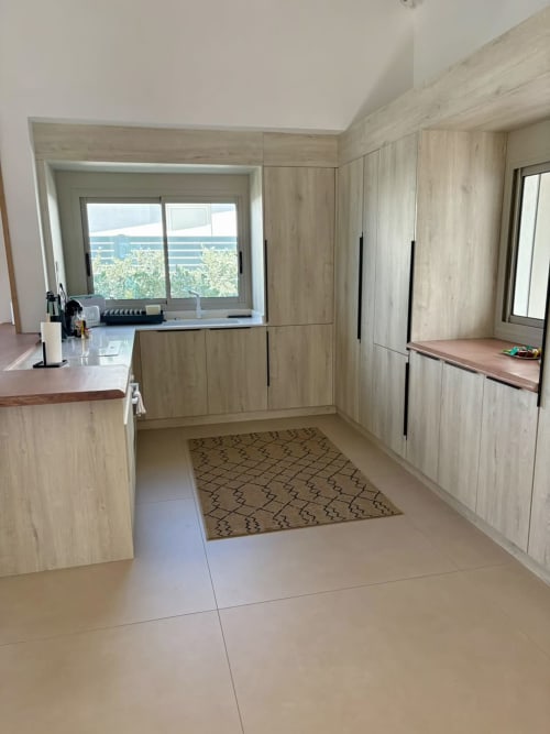 Cuisine moderne à Maly Blue Location avec mobilier en bois clair, vue sur la mer et tapis à motifs géométriques