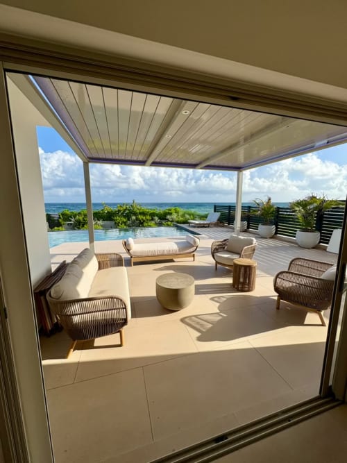Terrasse face mer du Maly Blue au Moule avec salon de détente, piscine et vue sur la mer des Caraïbes