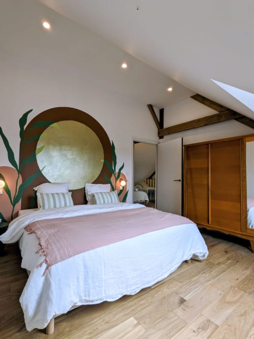 Chambre moderne à la Domaine De La Souche avec tête de lit circulaire, art botanique, literie blanche et poutres en bois à Rexpoëde