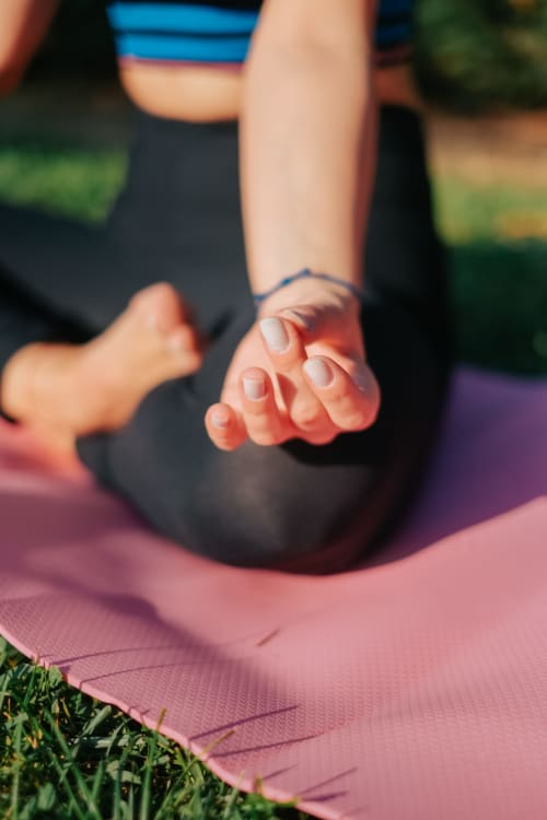Mano di bambino durante una sessione di yoga all'aperto al Borgo di Erboli, centro benessere a Cavriglia