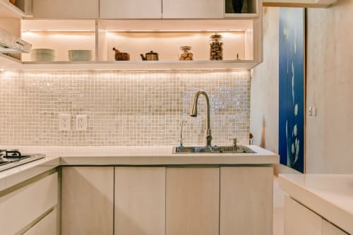 Modern kitchen with white tile backsplash, stainless steel sink, and illuminated cabinetry at Casa Rocka Isla Mujeres