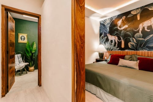 Luxurious bedroom at Casa Rocka with jungle mural, wood accents, and garden view in Isla Mujeres