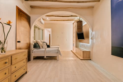 Spacious cottage living area at Casa Rocka Isla Mujeres with wooden furnishings, arched doorway, and modern amenities