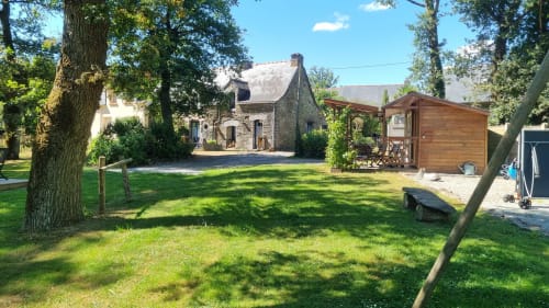Chambres d'hôtes le Clos du Tay à La Gacilly : maison en pierre avec pelouse, petit cottage en bois et arbres matures