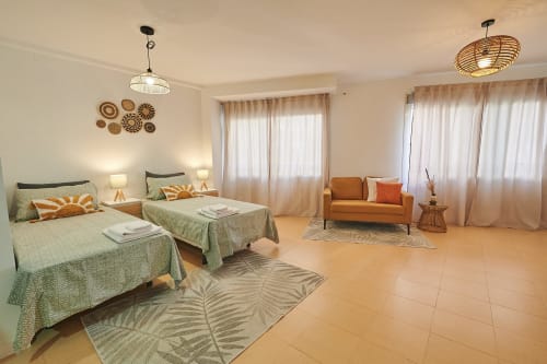 Bright double bedroom with twin beds, orange sofa, modern furnishings and city views at Mendez Nuñez Sunny Flat, Castelló de