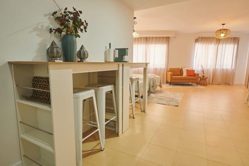 Bright open-plan apartment at Mediterranea Sunny Keys with kitchen island, dining area, and living room with orange sofa and