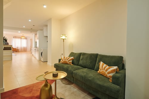 Green sofa with orange pillows in modern living room of Mendez Nuñez Sunny Flat, Castelló de la Plana