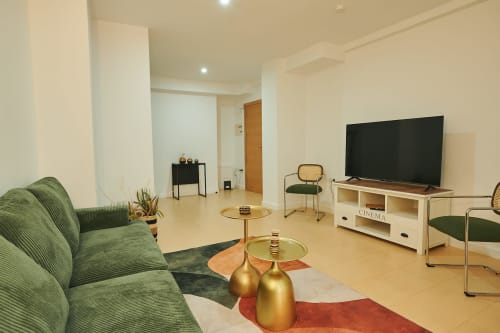 Modern living room at Mendez Nuñez Sunny Flat in Castelló with green sofa, flat-screen TV, and city view in this apartment