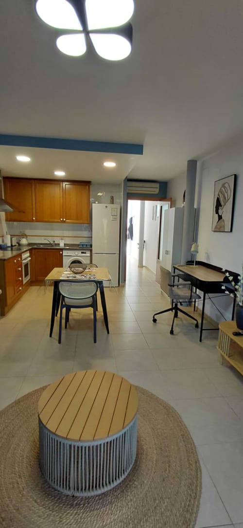 Cuisine ouverte et séjour du Sunny Flat Pont de Ferro à Benicàssim avec meubles en bois, table à manger et design moderne
