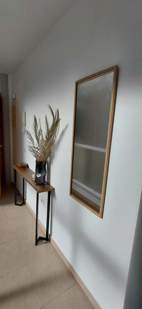 Couloir moderne à Mediterranea Sunny Keys avec miroir à cadre bois, console et herbe de pampa séchée en vase noir