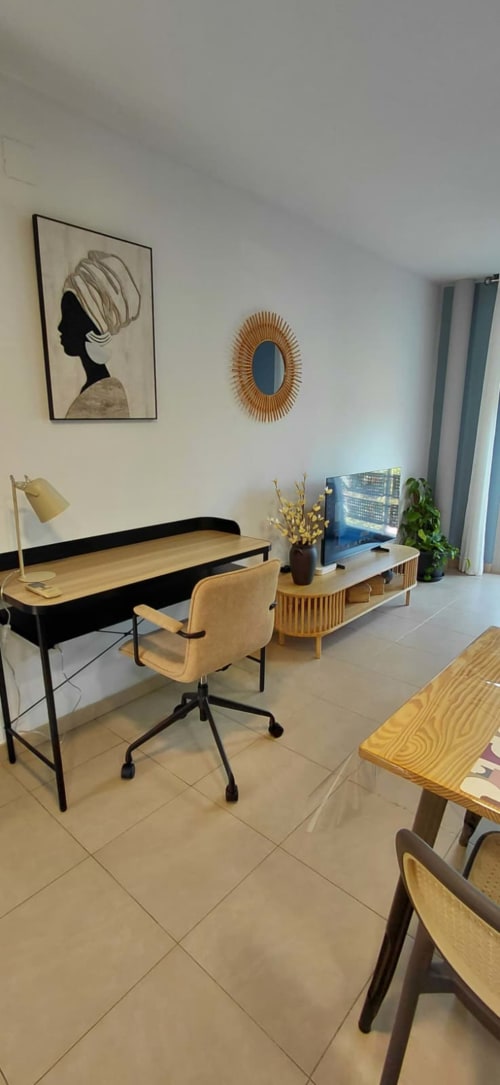Espace de travail moderne dans l'appartement Mediterranea Sunny Keys avec bureau, chaise, mobilier en bois et vue sur la ville de Benicàssim
