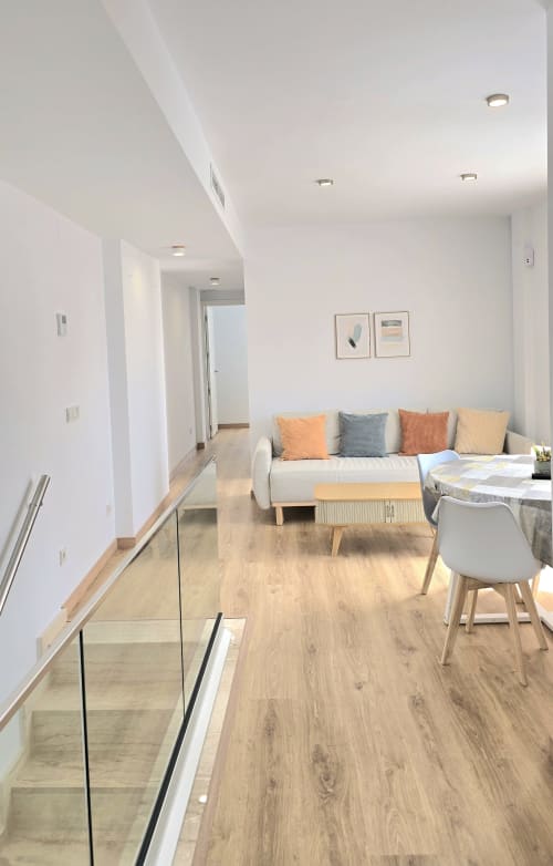 Modern apartment living area with sofa, dining table, wooden flooring at Mediterranea Sunny Keys, Benicàssim