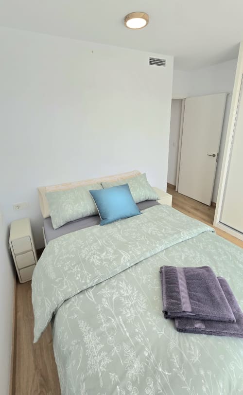 Bright bedroom in García Sanguesa Sunny Flat apartment, Benicàssim, with queen bed, blue pillow, and white closet doors