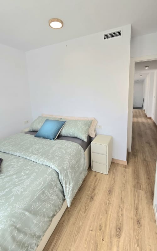 Modern bedroom in García Sanguesa Sunny Flat apartment, Benicàssim, with green patterned bedding, blue pillow, white