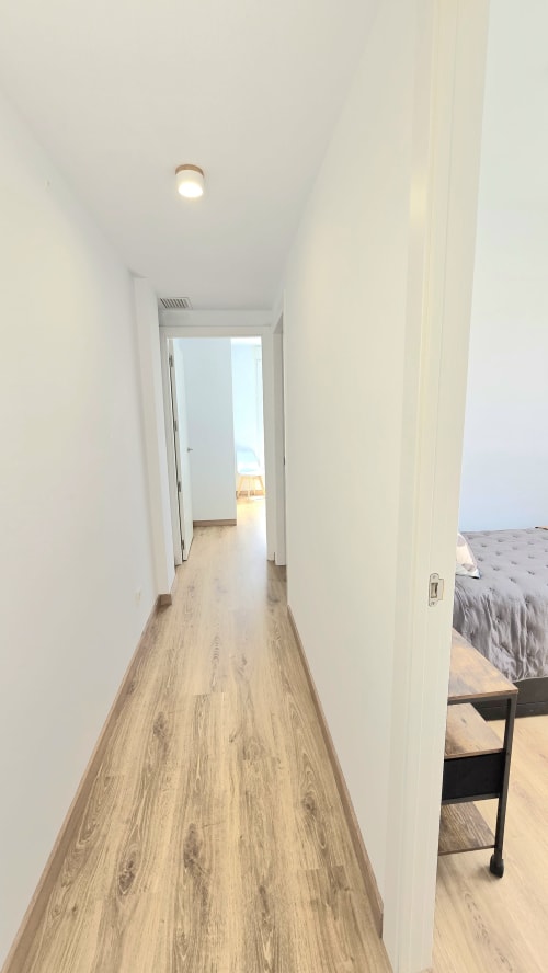 Bright hallway with wooden floors leading to bedroom in García Sanguesa Sunny Flat, Benicàssim apartment