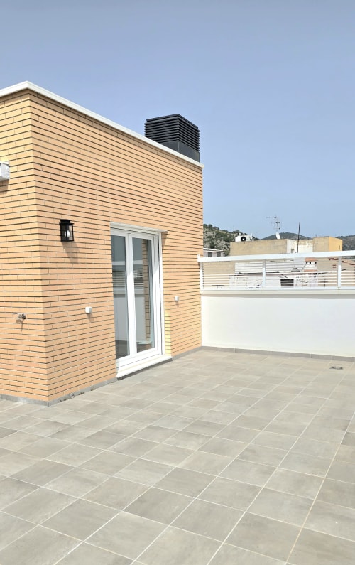 Modern rooftop terrace at Mediterranea Sunny Keys apartment in Benicàssim with tiled patio and mountain views