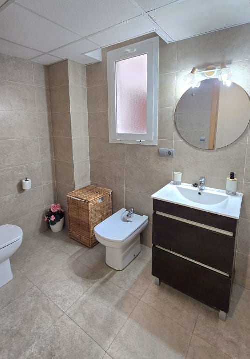 Modern bathroom in Els Dolors Sunny Flat, Benicàssim with vanity, bidet, mirror, and tiled walls