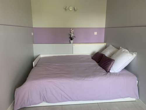 Chambre moderne avec literie violette et oreillers blancs au gîte L'etoile Filante près du Puy du Fou, France