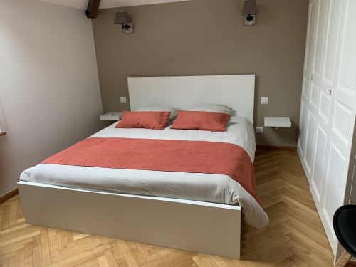 Chambre moderne à L'Étoile Filante B&B à Saint Christophe du Bois avec lit blanc, literie corail et parquet chevron