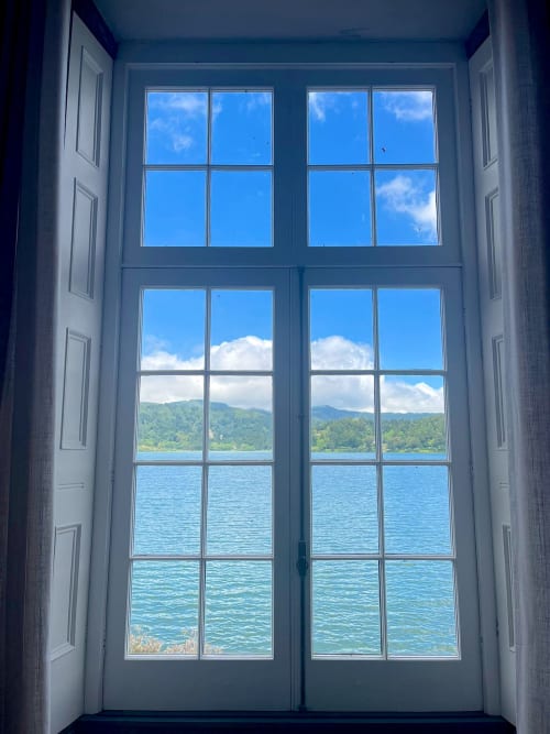 Double doors open to stunning lake and mountain views from Casa Dos Barcos cottage in Furnas, São Miguel