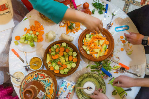 Cours de cuisine au Riad Dar Tahri à Fès avec préparation de légumes frais dans des bols en terre cuite traditionnels