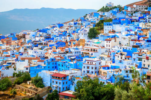 Des bâtiments peints en bleu s'étagent sur la colline de Chefchaouen, au Maroc près de Fès, mettant en valeur l'architecture marocaine traditionnelle