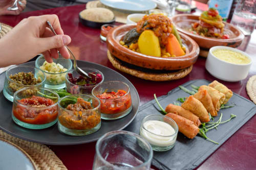 Assortiment de mezze marocains au Riad Dar Tahri à Fès, avec petits plats, trempettes, tajine et pâtisseries frites