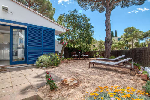 Jardí privat de la casa rural Finques Garcia Enrich a Palafrugell amb gandules, terrassa, persianes blaves i plantes florides