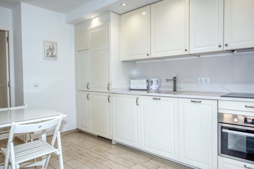 Cuina blanca moderna equipada amb zona de menjador en l'allotjament rural Casa Golfet a Palafrugell.