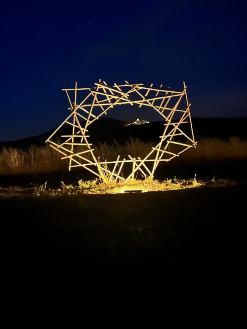 Instalación de arte geométrico iluminado en Casale Artemisia en Capalbio, Toscana, enmarcado contra el cielo nocturno