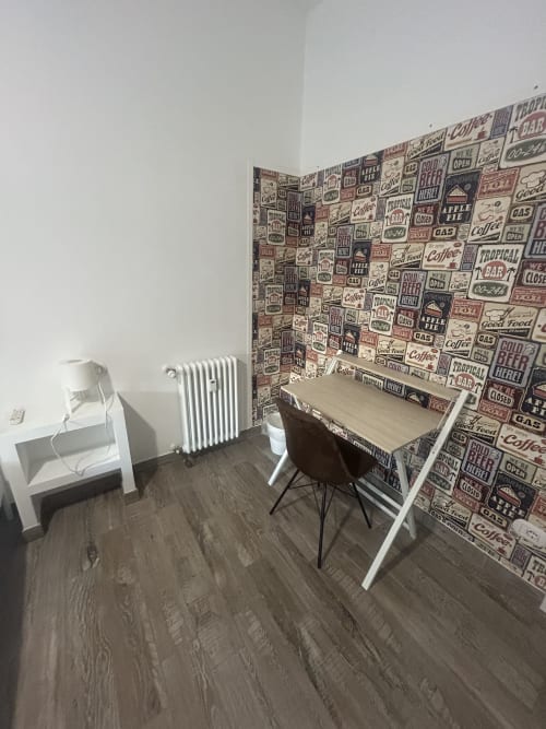Spazio di lavoro moderno in camera presso B&B GATE 10 Bologna con scrivania, carta da parati stile diner vintage e termosifone bianco