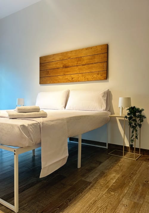 Camera moderna della B&B Gate 10 Fiera Bologna con letto bianco, testata in legno e comodino con lampada