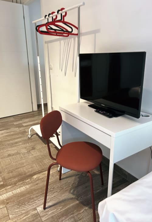 Moderno desk della camera d'albergo con sedia rossa e TV presso B&B GATE 10 Fiera Bologna
