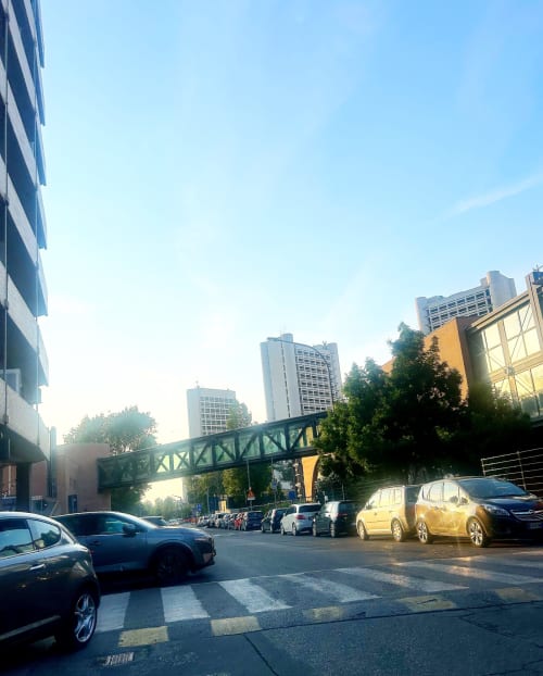 Vista urbana della B&B Gate 10 Fiera Bologna con auto parcheggiate, passerella pedonale e edifici moderni sotto cielo sereno