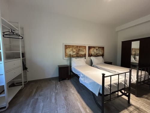 Camera doppia al B&B GATE 10 FIERA BOLOGNA di Bologna con due letti in metallo, biancheria bianca e pavimento in legno scuro