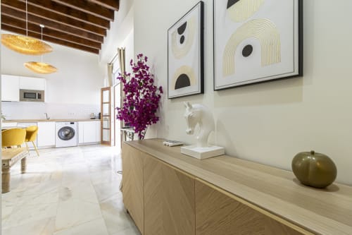 Modern SherryLola Cathedral apartment in Jerez showing open-plan living with white kitchen, wooden furniture, purple flowers,