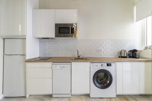 Modern kitchen in SherryLola Cathedral apartment at G&H Apartments, Jerez de la Frontera, with white cabinetry and wood