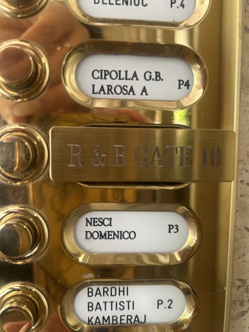 Pannello videocitofono in ottone al Gate 10 della B&B di Bologna con nomi dei residenti e numeri degli appartamenti