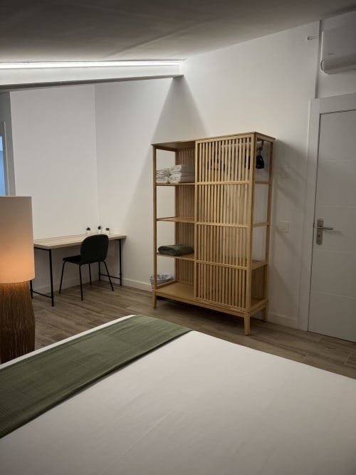 Habitació moderna a l'Hotel Oreneta de Gironella amb emmagatzematge de fusta, escriptori i llit amb camí de taula verd