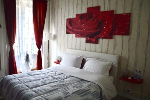 Rosa room at I colori della Sicilia B&B in Caltagirone with white bed, red artwork, red curtains and landmark view